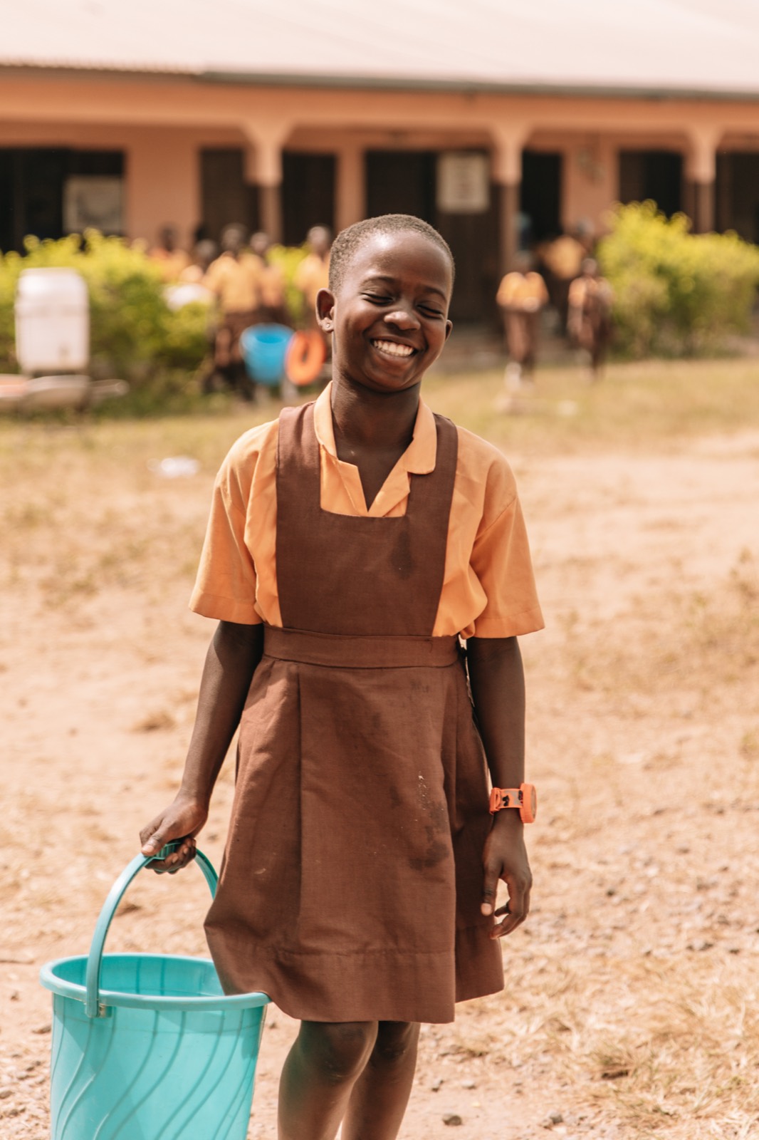A schoolgirl laughing in her schoolyard