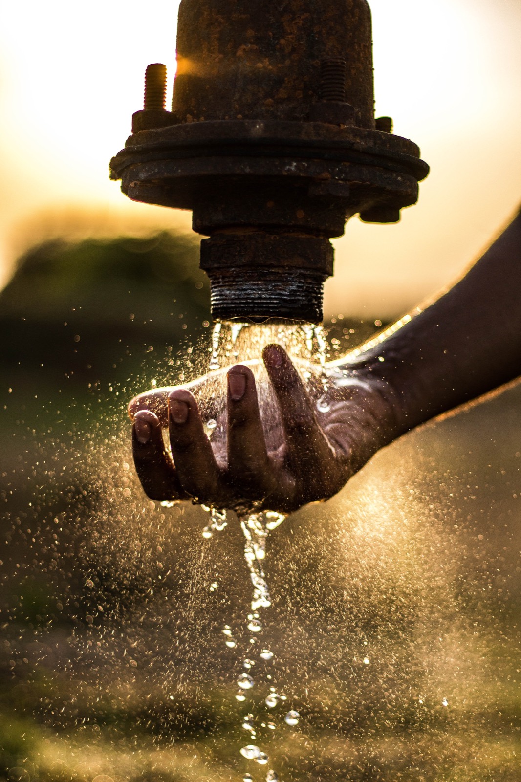 Water from a borehole tap pouring over a hand